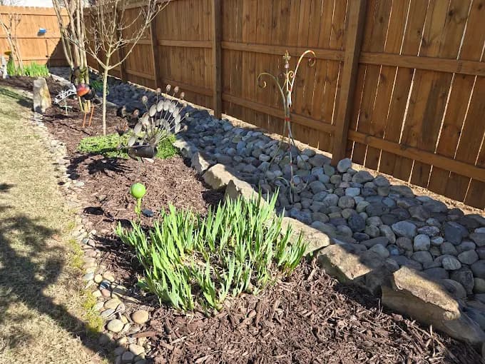 Garden bed with river stone edging and mulch